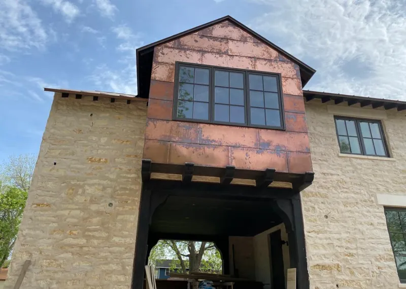 Copper metal panel facade on a stone building for Skylight Installation in East Niles
